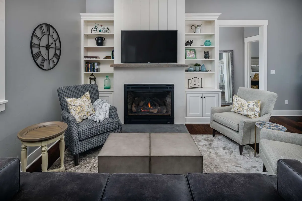 This interior image shows a cozy sitting area with a fireplace, comfortable seating, shelves with decor, and a TV. The space looks inviting and is suitable for relaxing, socializing, or movie nights. It reflects the section’s mention of the multi-use game/media room and provides a glimpse of the type of indoor comfort and entertainment available for families.