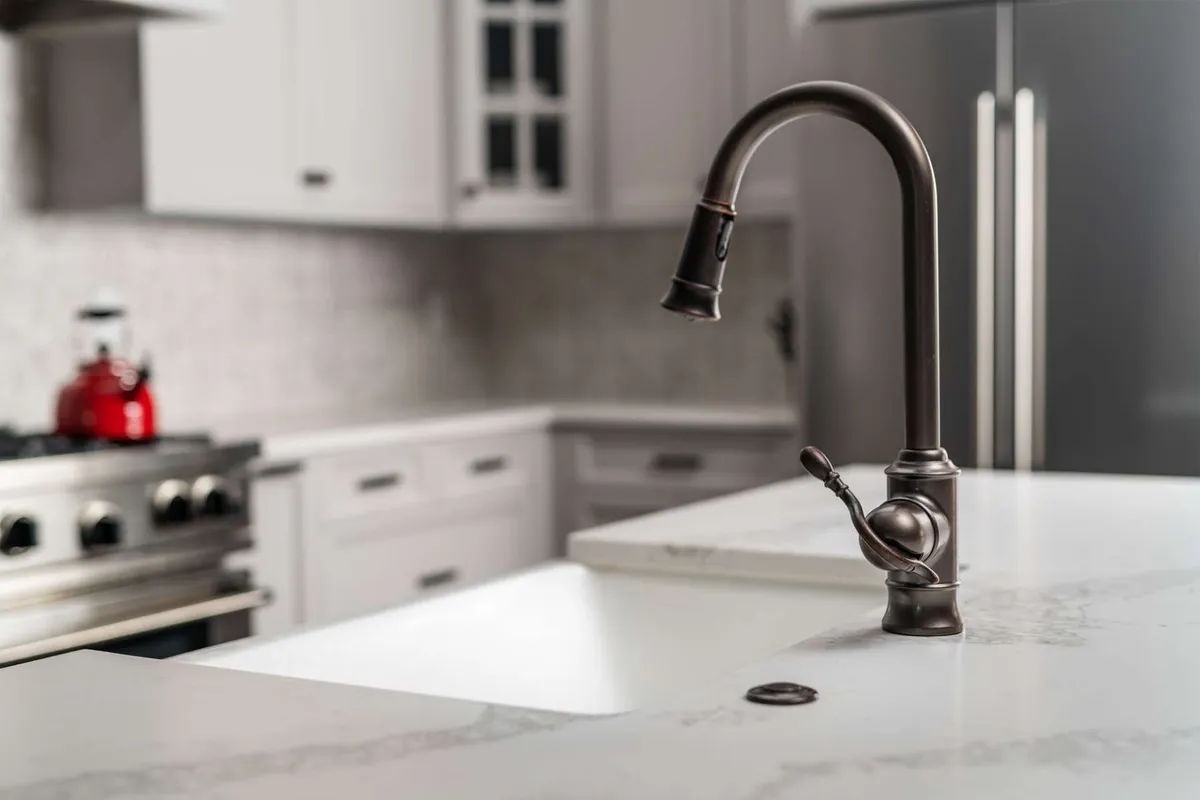 A bright, modern kitchen with sleek marble countertops, stainless steel appliances, and a chef-quality faucet. The space is designed for both cooking and socializing, with ample room for entertaining or preparing gourmet meals.